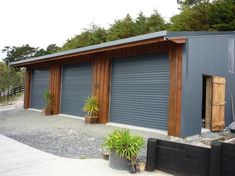 two garages with one door open and the other closed in front of some trees