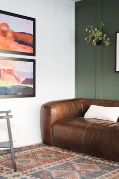 a brown leather couch sitting on top of a rug