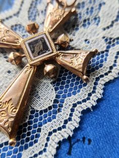 Antique cross pendant, dating from the nineteenth century, rose gold plated, engraved and enameled. There is a religious motif on one side and a floral motif on the other. The cross shows several signs of wear. There are a few chips on the enameled part with a flower. The plating is gone in places and there are small marks and indentations. The cross is very light. Dimensions: about 5.9 cm x 3.8 cm. Possible variations of color due to the light. Antique Crucifix Collectible Jewelry, Antique Collectible Crucifix Jewelry, Antique Cross Pendant Necklace For Formal Occasions, Antique Bronze Cross Necklace, Antique Cross Jewelry With Large Pendant, Antique Collectible Cross Jewelry, Antique Cross Necklaces For Collectibles, Victorian Crucifix Jewelry For Gifts, Victorian Cross Necklace For Formal Occasion