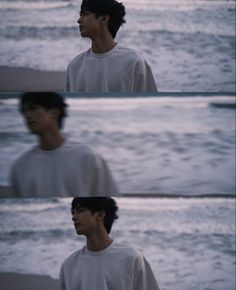 the man is standing on the beach by the water's edge and staring into the distance