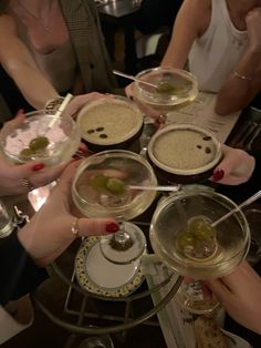 several people are holding wine glasses with food in them