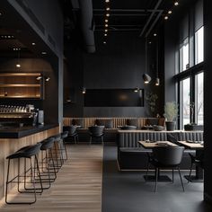 the interior of a restaurant with black walls and bar stools, wood flooring, and large windows