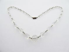 Beautiful necklace of faceted clear crystal beads in graduated teardrop and small bicone shapes with a circular bead at the centre.  They are strung on a fine silver tone chain and have a brass toned screw clasp.  The beads are very sparkly and in good condition with a few very tiny nicks on the  that do not show in reality 50 cm (19 ½ inches) To return to my shop's home page: https://www.etsy.com/uk/shop/jewelbirdvintage For more necklaces: https://www.etsy.com/shop/jewelbirdvintage?section_id=14476787 Crystal Bead Necklace, Art Deco Era, Glass Crystal, Vintage Art Deco, Fine Silver, Bead Necklace, Clear Crystal, Beautiful Necklaces, Crystal Beads