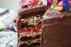 a piece of cake with chocolate frosting and flowers on the top is cut in half