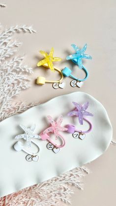 three pairs of hair clips sitting on top of a white plate next to snowflakes