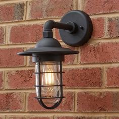 an outdoor light on the side of a brick wall