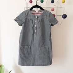 "Classic Bonpoint pin-striped  navy blue denim jean shift dress. Timeless. Featured details: Four button front closure, two front patch pockets. (extra button included) Size 8 In pristine condition. 100% cotton  *No returns or exchanges, please check measurements and feel free to ask any questions. Flat measurements: 10\" shoulders 15\" underarm to underarm 17.5\" waist 18\" hips 6\" sleeve 23.5\" total length" Blue Button-up Dress With Placket, Cotton Button-up Denim Dress With Snap Buttons, Blue Button-up Denim Dress With Button Closure, Striped Cotton Button-up Dresses, Indigo Button-up Cotton Denim Dress, Blue Denim Jeans, Shift Dress, Denim Jeans, Blue Denim