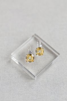 "With the look of luxury fine diamonds, the sparkle and presence of the Astor luxury earrings are something to behold. Small brilliant cut crystals cascade along the French hook style earpiece with a small brilliant cut crystal settling on top of a magnificent sparkling canary yellow asscher cut crystal. Beautifully realistic and elegant enough for everyday wear and also for evenings out and special occasions. The Asscher cut is a unique shape with prismatic brilliance and a rectangular-faceted Elegant Asscher Cut Diamond Earrings, Elegant Asscher Cut Diamond Accent Earrings, Elegant Silver Asscher Cut Earrings, Elegant Asscher Cut Earrings With Diamond Accents, Elegant Diamond Earrings With Asscher Cut, Asscher Cut Diamond Accent Earrings For Wedding, Silver Asscher Cut Earrings For Wedding, Elegant Sterling Silver Asscher Cut Earrings, Luxury Wedding Earrings With Lever Back Ear Wires