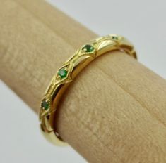 "This beautiful hand engraved and millgrain wedding band is 2.3 mm wide and 1.8 mm tall made of 18k yellow but we can make it in any 18k or 14k color of gold. The 7 tsavorite garnets are set approximately 2/3 way on top and have a total weight of .05 Cts. We can make it any size from 5-7 and you still be able to return it within the listed time frame. Sizing outside of that range can be made as a special order and may require a resize fee if returned. Ring sizing may add additional handling time Gold Art Deco Emerald Ring For Wedding, Anniversary Jewelry With May Birthstone, Gold Emerald Ring Hand Set As A Gift, Tsavorite Birthstone Rings For Wedding, Art Deco Yellow Gold Emerald Ring Stamped 14k, Wedding Jewelry Green Stamped 14k, Wedding 14k Stamped Green Jewelry, Wedding Green Jewelry Stamped 14k, Gold Wedding Jewelry With Certificate Of Authenticity