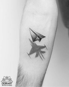 a black and white photo of a person's arm with an origami tattoo on