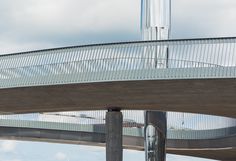 a skateboarder is doing a trick on the edge of a bridge over water