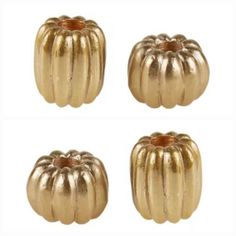 four gold metal pumpkins sitting on top of each other