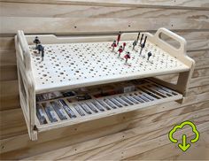 a wooden shelf with pegs on it and several different tools in the bottom drawer