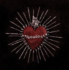 a red heart surrounded by lots of silver pins on a black background with a starburst in the middle