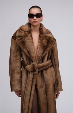 A re-invention of the iconic trench coat takes creative vision. This style aces the interpretation of a recognizable checked pattern, long epaulettes, and a belt to cinch it all together. But the best part is that it’s made from the coziest faux fur.  PRE-ORDER Luxury Brown Belted Outerwear, Luxury Belted Outerwear With Notch Lapel, Luxury Brown Long Coat, Luxury Long Mink Coat, Luxury Mink Long Coat, Chic Mink-colored Formal Outerwear, Chic Mink Outerwear For Formal Occasions, Chic Mink Formal Outerwear, Mink Long Coat For Work