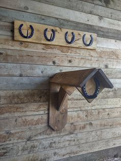 three horseshoes mounted to the side of a wooden wall