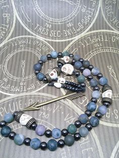 This is a beautiful re-imagined rosary based on the classic Catholic rosary. The beads are matte finish fancy jasper and the spacing beads howlite skulls. There are three decades of nine beads each. The center is a large howlite skull, and I have capped it off with Artemis's arrow and hematite and howlite dangles. With this rosary I'm including a simple chant which has resonated with me, but feel free to use your own! Pagan/witch prayer chant: Knot one, the work's begun. Knot two, my aim is true Bohemian Beaded Rosary Bracelet For Healing, Bohemian Rosary Bracelet With Natural Stones For Jewelry Making, Bohemian Rosary Bracelet With Gemstone Beads, Handmade Adjustable Spiritual Rosary, Bohemian Hand-strung Healing Rosary, Bohemian Hand-strung Rosary For Healing, Bohemian Rosary Bracelet For Healing With Natural Stones, Bohemian Rosary With 108 Beads For Healing, Bohemian Rosary Bracelet With Natural Stones For Healing