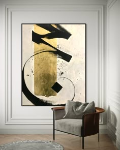 an abstract painting hangs on the wall above a chair in a room with white walls