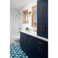 a blue and white bathroom with gold handles