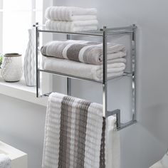 towels are stacked on the rack in front of a window