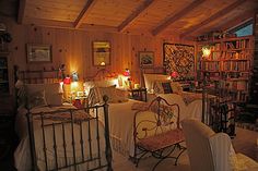 two beds in a room with bookshelves and lamps