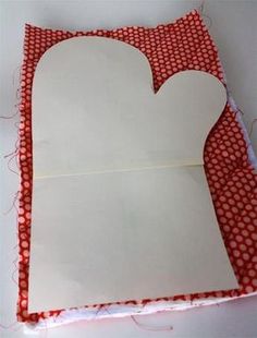 a piece of paper cut out to look like a heart on a red and white checkered cloth