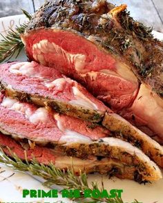 roast beef with herbs and rosemary on a white plate next to the words prime roast