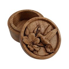 a wooden box with a bird and flower carving on the lid, in front of a white background