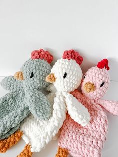 three crocheted stuffed animals sitting next to each other on a white table top