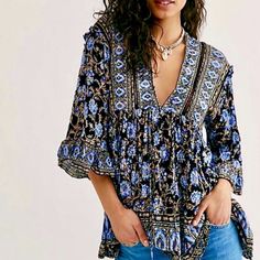 Embrace Your Inner Goddess In This Strikingly Beautiful Tunic From Free People, In An Exquisite Batik Floral Print Full Of Rich Blues, Camel Brown, Ivory & Black. Gorgeous As A Sexy Mini Dress Or Tunic Top Worn With Jeans. Full Of Intricate Details, It Features A Loose Flowy Silhouette, Deep V-Neckline With Self-Tie Closure, Crochet Inset, Drop Shoulders With Ruffle Details, Flared Sleeves With Wide Ruffles, Side Pockets & High-Low Hemline. 100% Viscose. Generously Sized. Approx. Bust 21”, Lengt Black Bohemian Printed Blouse, Black Floral Print Festival Blouse, Black Floral Print Blouse For Festival, Black Bohemian Blouse With Floral Print, Black Bohemian Top With Boho Print, Black Bohemian Tops With Boho Print, Boho Tunic Tops, Printed Tunic Tops, Waffle Knit Top