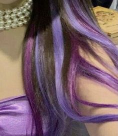 the back of a woman's head with long purple hair and pearls on it