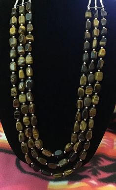 "Vintage Authentic Navajo Zuni Tiger's Eye Necklace Earrings Set with small Sterling Silver balls known as \"Navajo Pearls\" placed between the Tiger's Eye. Necklace length is 38 inches with 3 strands. Handcrafted by Navajo Artist R. Sellers Gorgeous Piece of Native American Art Great for a Gift❤️ The stripes of a tiger eye stone are representative of its believed power. The stone balances one's negative and positive energy to aid the wearer in finding their own personal balance within." Vintage Native American Jewelry Navajo, Vintage Navajo Jewelry Gold, Vintage Navajo Jewelry Indie And Harper, Vintage Navajo Earrings, Vintage Native American Jewelry Stone, Navajo Necklace, Tigers Eye Necklace, American Indian Jewelry, Southwestern Jewelry