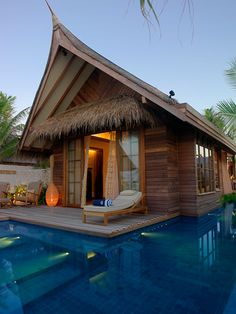 a small wooden house sitting next to a swimming pool