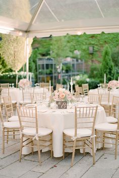 the tables are set with white linens and gold chairs for an elegant wedding reception