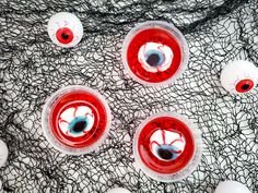 four red and white circles with holes in them on a piece of black netted material