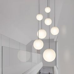 a bunch of lights hanging from the ceiling in a room with white walls and flooring