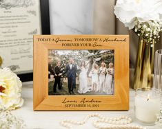 a personalized wooden frame for a wedding photo with flowers and pearls on the table