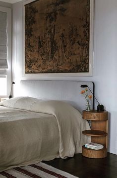 a bedroom with a large painting above the bed