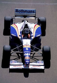 a man driving a race car down a street