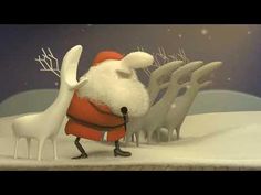 a santa clause is standing in the snow next to some white reindeers and holding a microphone