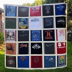 a quilt made out of t - shirts sitting in the grass