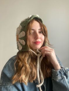 a woman wearing a knitted hat with flowers on it