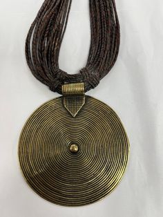 A beautiful handmade brass pendant from Ghana hangs on a hand weaved leather. The necklace is a collectible art and would be perfect for adding to your African jewelry collection or a major statement piece to wear. Black African Necklace, Vintage Brown Jewelry With Adjustable Cord, Brown Necklace With Adjustable Cord For Festivals, Festival Metal Necklace With Adjustable Cord, Vintage Gold Necklaces With Adjustable Cord, Brown Metal Jewelry With Adjustable Cord, Metal Pendant Jewelry With Adjustable Cord, Adjustable Cord Metal Necklace For Festivals, Traditional Handwoven Gold Jewelry