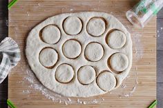 an uncooked pizza sitting on top of a wooden cutting board