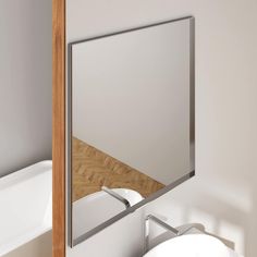 there is a mirror in the corner of this bathroom with a sink and bathtub