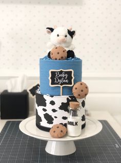 a three tiered cake with chocolate chip cookies on it and a cow figurine