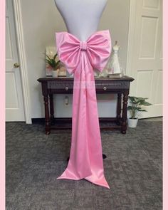 a dress form with a pink bow on it