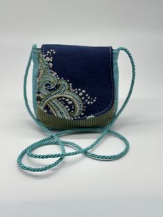 Make a statement with this one-of-a-kind bag featuring a stunning self-designed pattern in a beautiful blend of navy blue, turquoise, and green.  The compact size (4" x 5" x 1.5") is perfect for carrying your essentials, while the convenient back pocket keeps smaller items secure. Carry it comfortably with the luxurious 50-inch long satin turquoise cord handle that adds a touch of elegance. Self Design, Mini Crossbody Bag, Mini Crossbody, Purse Pouch, Navy Blue, Crossbody Bag, Coin Purse, Pouch, Navy