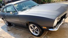 an old muscle car is parked in the driveway