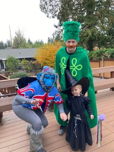 two children and an adult in costumes on a deck